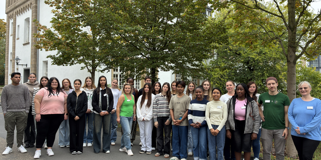 Kurs O26 Gruppe junger Menschen steht zusammen und schaut in die Kamera.