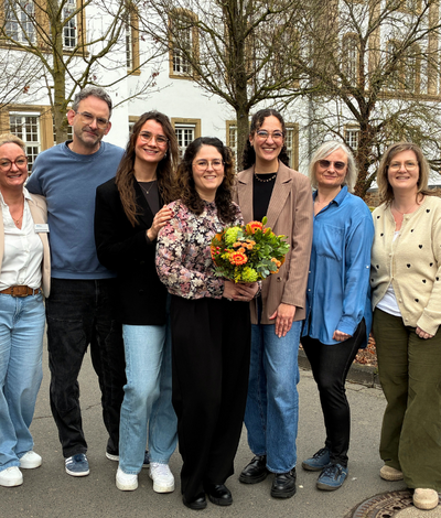 Despoina Braun bekommt im Kreis des Teams der Pflegeschule einen Blumenstrauß